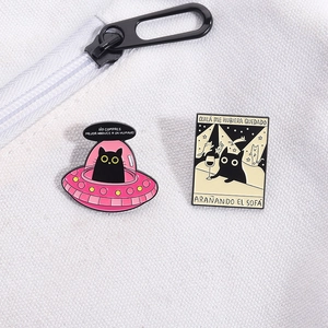 Detail von schwarze Katze Emaille-Pins auf weißem Stoff mit hochwertiger Metalltextur