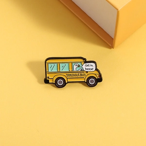 Dettaglio macro della spilla bus giallo con papera carina e frase divertente