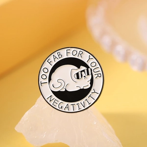 Detail of round enamel cat pin showing Too Fab For Your Negativity slogan and cool white cat