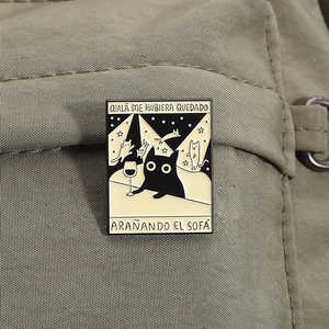 Detail der Emaille-Anstecknadel mit schwarzer Katze und Text auf einer grünen Nylontasche