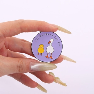 Détail du pin's rond en émail violet avec oie blanche et citation I'll be there for you