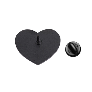 Detail of matte black heart enamel pin showing the back needle and rubber clutch closure