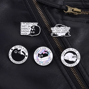 Detailed shot of five cartoon cat enamel pins displayed on a black leather jacket texture