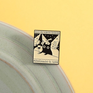 Künstlerische Emaille-Anstecknadel mit schwarzer Katze und spanischem Text auf gelbem Grund