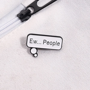 Macro shot of Ew People enamel pin attached to white canvas fabric with metal texture