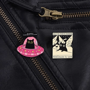 Detail von schwarzen Katzen-Emaille-Pins auf Lederjacke mit UFO- und Weinbar-Motiven