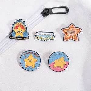 Detailed view of five colorful star enamel pins with positive quotes on a white canvas bag