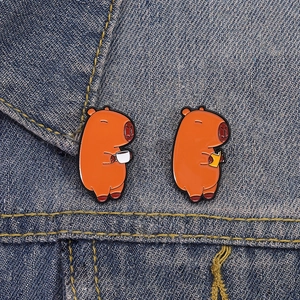Cute Capybara enamel pins with coffee and book designs on blue denim jacket