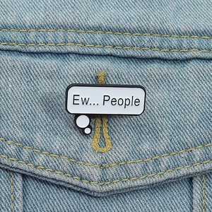 Detail showing the Ew... People enamel pin badge attached to a blue denim jacket texture