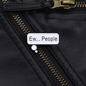 Detail of white enamel 'Ew... People' brooch pinned on a black leather jacket lapel