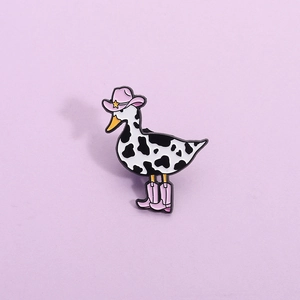 Creative pink cowboy duck enamel pin with cow pattern and star hat on purple background