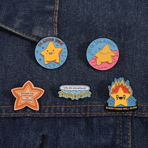 Detailed view of colorful star enamel pins with motivational quotes on denim fabric