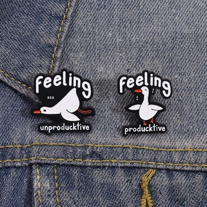 Détail de pin's en émail oie sur veste en jean avec texte humoristique producktive