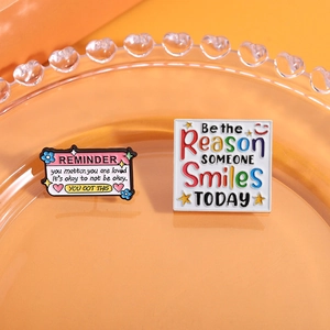 Pins en émail inspirants avec slogans positifs en anglais sur fond orange chaleureux