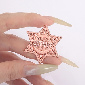 Close-up of rose gold hexagonal star sheriff badge with detailed metal engraving