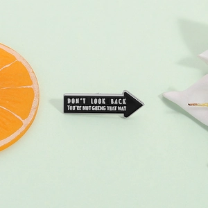 Arrow enamel pin badge with inspirational quote on mint background with orange slices