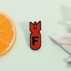 Red bomb enamel pin with letter F on a minimalist background for daily wear