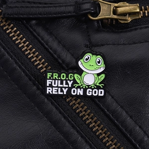 Detail van groene kikker emaille speld met tekst op een zwart leren jack voor kleding