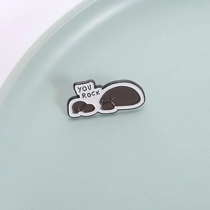 Creative gray stone enamel pin with 'YOU ROCK' text in minimalist aesthetic style