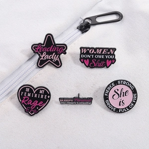 Detail von fünf feministischen Emaille-Pins auf Stofftasche mit Leading Lady Spruch