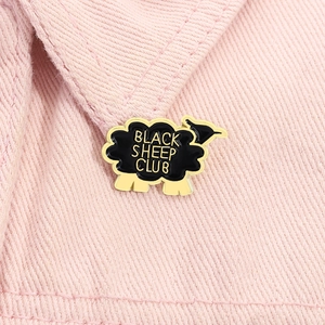 Détail de la broche en émail Black Sheep Club épinglée sur un tissu en denim rose