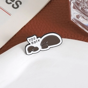 Enamel rock pin with YOU ROCK text on white ceramic plate with a cozy aesthetic vibe