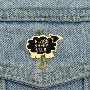 Gros plan du pin's émaillé Black Sheep Club sur une poche de veste en jean
