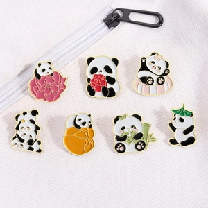 Detail von 7 süßen Panda-Emaille-Pins mit Goldrand auf weißem Stoffhintergrund