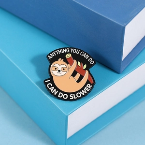 Detail of sloth enamel pin with humor quote on blue book edge in macro view