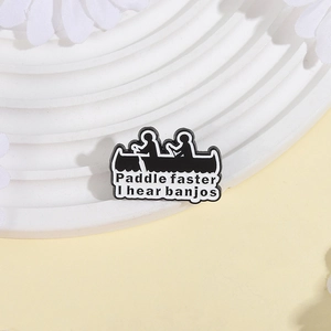 Detail shot of the black enamel badge featuring a rowing silhouette and funny typography