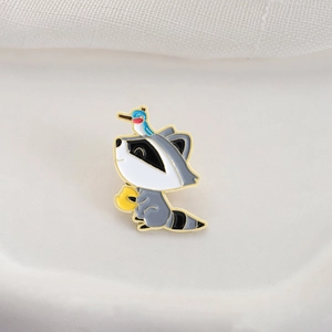 Broche en émail raton laveur mignon avec petit oiseau bleu sur fond crème doux