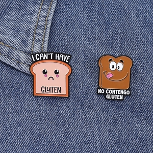 Nahaufnahme süßer glutenfreier Toast-Emaille-Pins auf blauem Jeansstoff Hintergrund