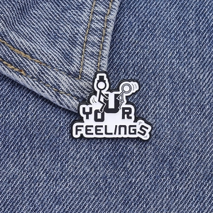 Macro shot of Fuck Your Feelings stickman enamel pin on blue denim fabric background