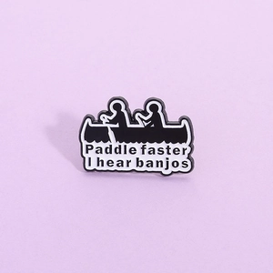 Black rowing silhouette enamel pin with white text Paddle faster I hear banjos engraving