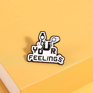 Detail of creative enamel pin with black and white humor design and text YOUR FEELINGS