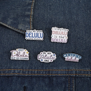 Vue détaillée de cinq épingles en émail coloré sur un tissu en denim bleu