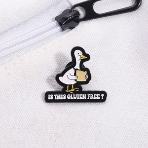Gros plan détaillé d'un pin's canard en émail avec du pain sur un sac en toile