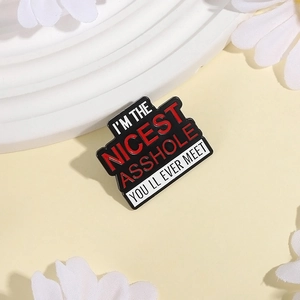 Detail einer kreativen Emaille-Brosche mit rotem Slogan auf einem weißen Display