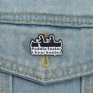 Detail of Paddle Faster I Hear Banjos enamel pin on a denim jacket pocket
