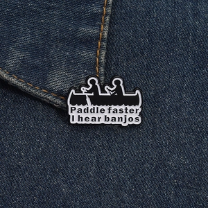 Detail of Paddle faster I hear banjos enamel pin on a denim jacket background