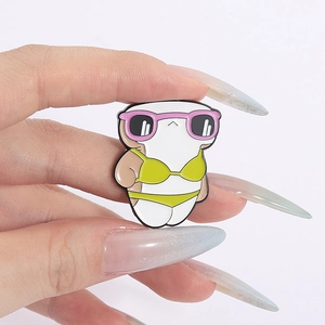 Detail of shark enamel pin with pink sunglasses and yellow bikini on a metal badge