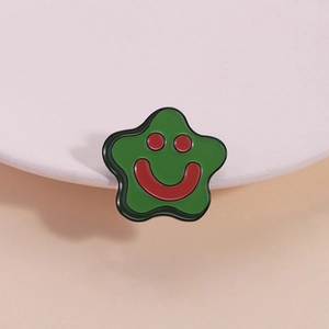 Cute green starfish enamel pin with red smiley face on elegant ceramic display