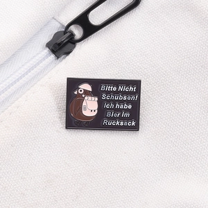 Détail du badge émaillé humoristique sur sac en toile avec oiseau et texte en allemand