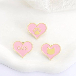 Gros plan détaillé des badges chat rose en forme de cœur avec bordures en métal doré