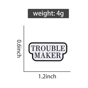 Detail showing dimensions of TROUBLE MAKER enamel pin badge at 1.2 by 0.6 inches