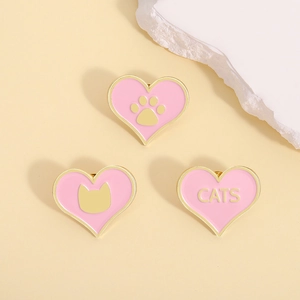 Trois épingles en émail rose en forme de cœur avec bordure dorée et motifs de chat