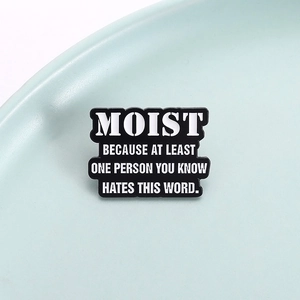 Macro detail of enamel pin with humor quote Most People Hate the Word Moist