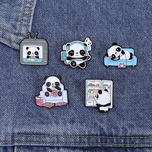 Detailed close-up of five cute enamel panda pins displayed on a blue denim background