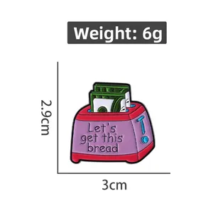 Detail showing pink toaster enamel pin with dollar bills and motivational text, 3cm size
