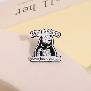 Detail of a black and white bear enamel pin with funny My flabbers have been gasted quote
